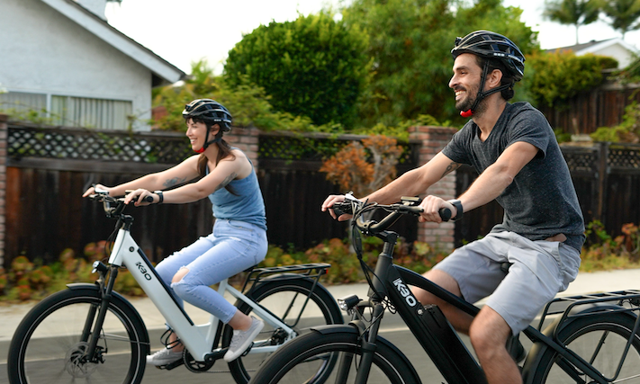 two people smiling and riding on ebikes