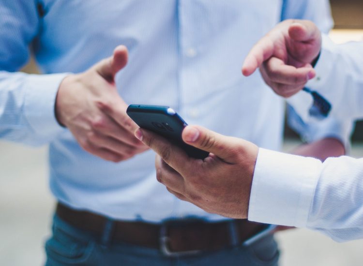 a typical networking scene sharing contact info on a cell phone